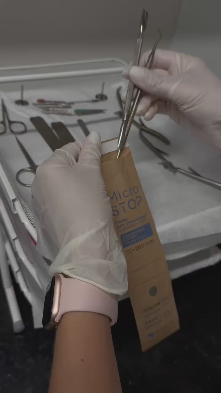 Placing manicure tools into MicroSTOP sterilisation pouch using tweezers